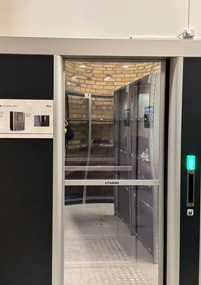 Q-Gate-puhdastilan kulkuportti lasiovella ja vihreällä merkkivalolla varustettuna.