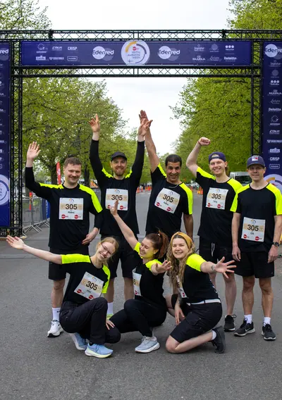 Yritysmaratonin osallistujaryhmä poseeraa maalialueella